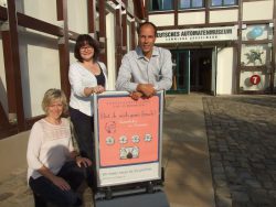 Hereinspaziert: Die Ausstellungen sind geöffnet, darauf weisen Museumsleiter Sascha Wömpener und die Museumsmitarbeiterinnen Heike Bohbrink und Jessica Midding hin.