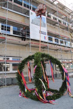 Das bringt Glück: der Richtkranz wurde feierlich auf das Gebäude gehoben und der Richtspruch von Dachdeckermeister Daniel Wiens verlesen.