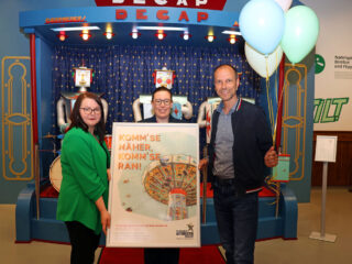 Automaten als fester Kirmesbestandteil: Jessica Midding (stellvertretende Leitung Automatenmuseum, von links), Larissa Mattlage (Leitung Schloss Benkhausen) und Sascha Wömpener (Leiter Automatenmuseum) freuen sich auf die neue Sonderausstellung. (Foto: Deutsches Automatenmuseum)