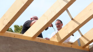 Symbolischer Akt: Kita-Leiter Christian Albrecht (links) und Merkur-Immobilien-Geschäftsführer Lars Reichel drehen die letzte Schraube ins Gebälk. (Foto: Merkur Group)