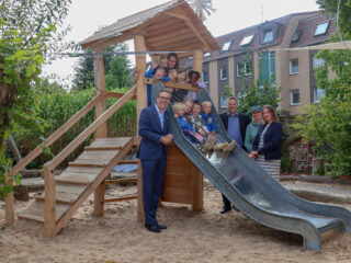 Gemeinsam mit den Kindern der Kindertagesstätte Pusteblume freuen sich Mario Hoffmeister (von links), Christine Westfal, Sven Stallmann, Sandra Wölfing, Geschäftsführerin der Elterninitiative Lübbecke, und Samantha Ern, stellvertretende Vorsitzende der Elterninitiative Lübbecke, über den neuen Spielturm. (Foto: Merkur Group)