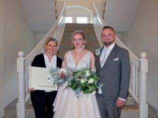 Außergewöhnliches Jubiläum: Antonia Breitensträter und Levin Babacan sind das 500. Brautpaar, das sich auf Schloss Benkhausen trauen ließ. Das freut auch Sonja Spilker, stellvertretende Leiterin von Schloss Benkhausen, die die Trauungen organisiert und jedes Mal ein Fotoalbum als Geschenk überreicht. (Foto: Merkur Group)