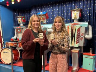 Roboter als Spardose: Karolin Vogt (links) und Fabiana Kresse präsentieren das fertige Produkt des Ferienworkshops. (Foto: Merkur Group)