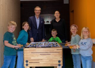 Im Namen der Paul und Karin Gauselmann Stiftung übergibt Mario Hoffmeister (links) den Kicker an die OGS Isenstedt. Darüber freuen sich Sabrina Collin und die Schülerinnen und Schüler.