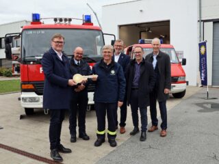 Hans Martin Grube (links, Geschäftsführer Produktion adp Merkur) überreicht den symbolischen Schlüssel an Dirk Beste (Dritter von links, Einheitsführer Tagesalarmbereitschaft). Das freut auch Maik Entgelmeier (stellvertretender Leiter Feuerwehr Lübbecke), Finanzdezernent Dirk Raddy, Lars Reichel (Merkur Immobilien) und Bürgermeister Frank Haberbosch. (Foto: Merkur Group)