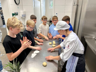 Los geht es: In der Küche wurde den Schülern unter anderem gezeigt, worauf es beim Formen der Kartoffelknödel ankommt. (Foto: Merkur Group)