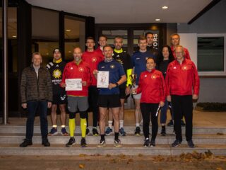 Paul-Jürgen Zuleger (links) übergibt neben der Auszeichnung als fitteste Betriebsgruppe auch einen Scheck über 100 Euro an die glücklichen Mitglieder der Merkur Runners. (Foto: Merkur Group)