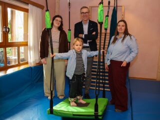 Mario Hoffmeister (Mitte) überreicht die neue Schaukel an Sarah Kirchhoff und Astrid Kuhlmann. Olivia findet bereits großen Gefallen an ihr. (Foto: Merkur Group)