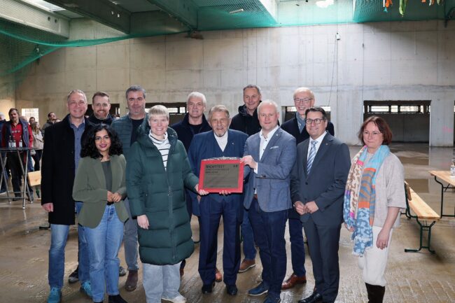 Große Freude beim Richtfest: Gemeinsam mit den politischen Honoratioren auf Bundes-, Landes- oder Kreisebene bedankt sich Espelkamps Bürgermeister Dr. Henning Vieker (Dritter von rechts) bei Paul Gauselmann (Mitte) für die großzügige Unterstützung der neuen Sporthalle. (Foto: Merkur Group)