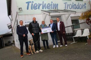 Stolze Summe: Martin Thomauske, Sven Breidenbach mit seinem Hund Ryder, Helga Berben, Thomas Stoßberg, und Rhein Fire-Geschäftsführer Daniel Thywissen freuen sich über die Spende in Höhe von 2.021 Euro. (Foto: Merkur Group)