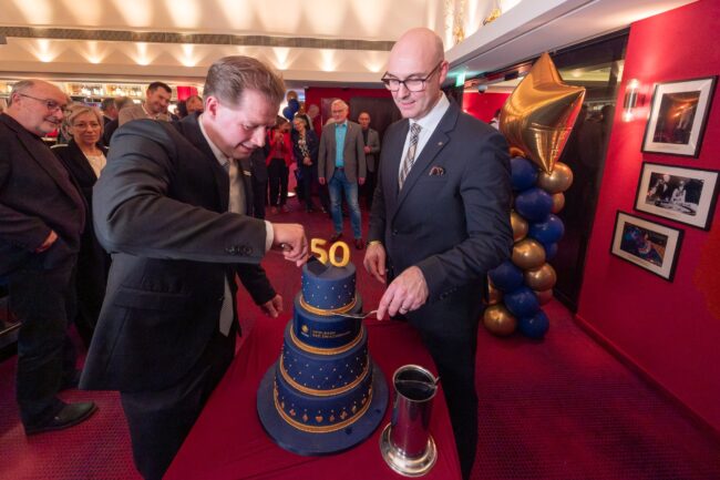 Henning Dierks (links) und David Schnabel schneiden gemeinsam die Torte zum 50-jährigen Jubiläum der Merkur Spielbank Bad Zwischenahn an. (Foto: Sascha Stüber)