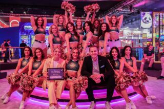 Juliane Engelking, Head of Marketing & Customer Experience der adp Merkur, und Jan Schürmeyer, Senior Manager to the Board der adp Merkur, freuen sich gemeinsam mit den Merkur-Cheerleadern über den Erhalt des ICE StandOut Awards in der Kategorie „Best Onsite Marketing Activation“. (Foto: Merkur Group)