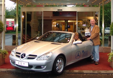 Das glückliche Gewinnerehepaar holt ihren Auto-Jackpotgewinn ab.